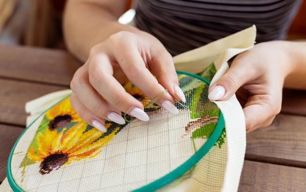 Рукодельница вышивает цветок